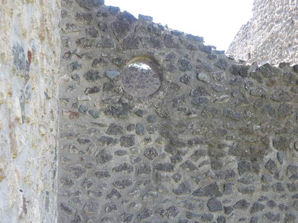 IX.14.4 Pompeii. May 2017. Circular window into room 8 the latrine, looking west from garden area 2. Photo courtesy of Buzz Ferebee.
