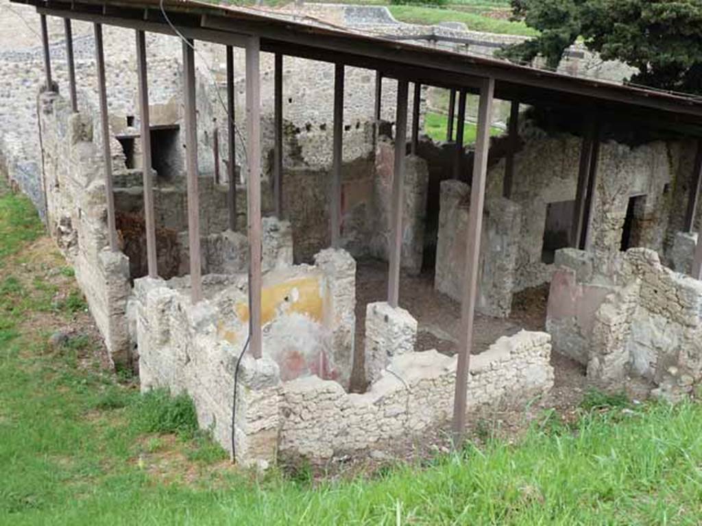 IX.14.c Pompeii. May 2010. Looking north-east. Room 7 is in the foreground with its doorway to the south side of the atrium. To the right of the doorway, front right in this picture, is one of the cupboards that flanked the entrance to room 8. According to NdS, at the sides of the entrance corridor were two rooms 4 and 5. The room with the north wall painted red and yellow is room 5. Room 5 had a similar wall decoration to room 4, which was a low black plinth, red decorations and yellow frieze. See Notizie degli Scavi di Antichit�, 1911, p. 375.