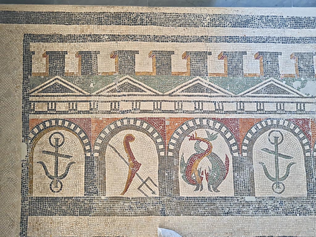 Villa of Diomedes ? or VI 17.10 Pompeii ?. June 2024.  
Detail from mosaic of “doors”, starting with an anchor, trident, two dolphins, an anchor, one dolphin, and a stern of a ship with rudder. 
On display in Naples Archaeological Museum, Room CXXXIV.  Photo courtesy of Giuseppe Ciaramella. 
