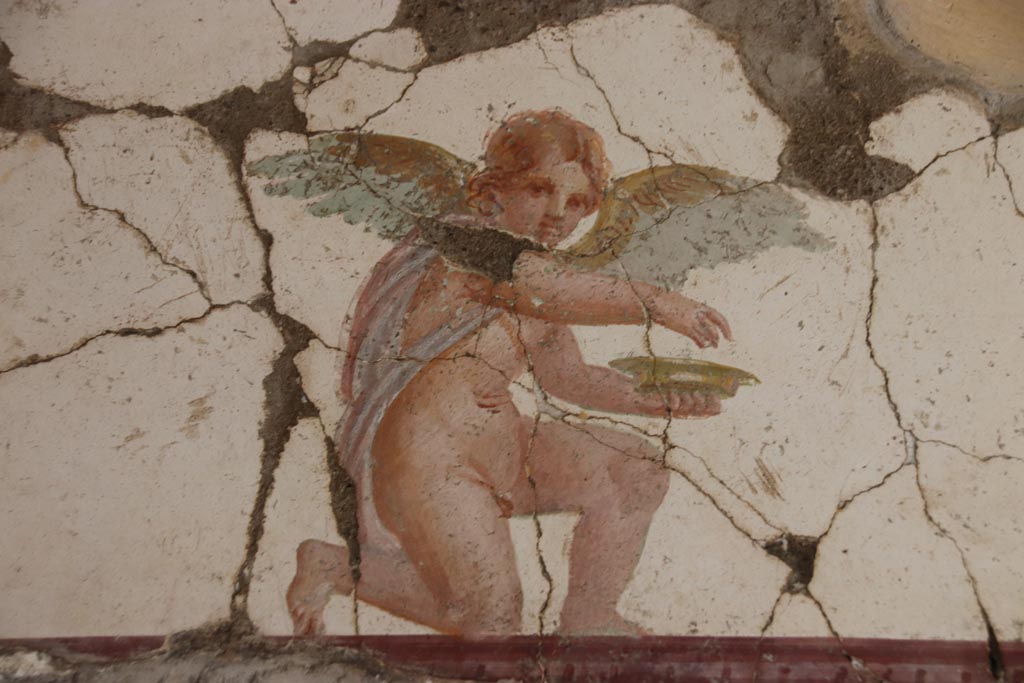 Villa San Marco, Stabiae, October 2022.
Room 30, detail of kneeling Eros holding a dish, from east wall above doorway to room 50, in north-east corner.
Photo courtesy of Klaus Heese.