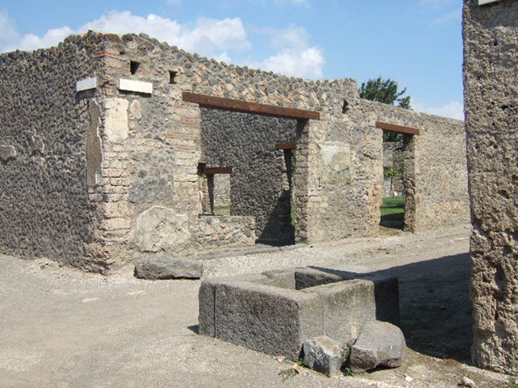 Unnamed vicolo (on left), I.11.11 on north east corner of junction with Via di Castricio (on right). September 2005. Looking east. South east corner with unrestored fountain. 
