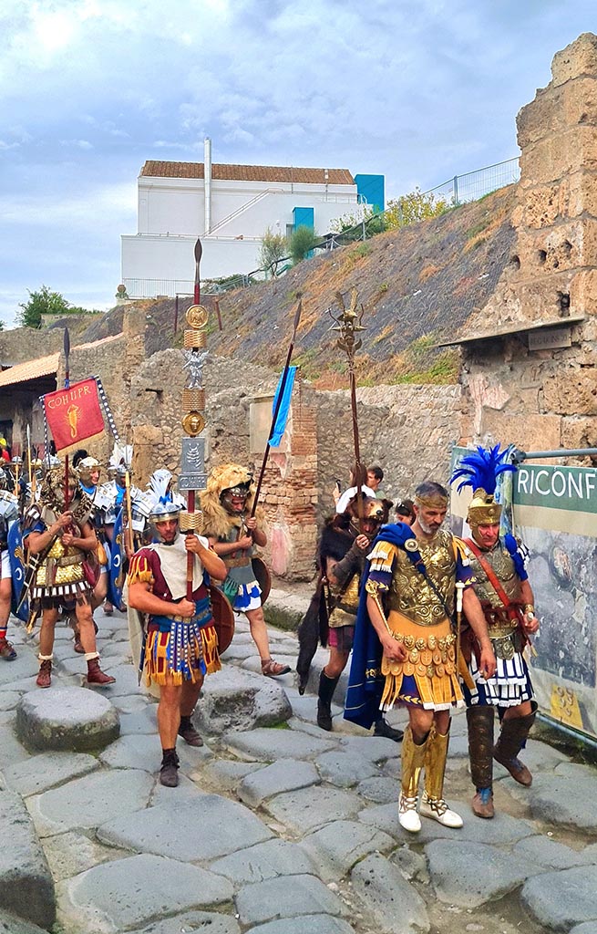 Via dell’Abbondanza, north side. 28th September 2024. Parade of re-enactors.
Looking west towards IX.11, in centre, during “Ludi Pompeiani” event. 
Photo courtesy of Giuseppe Ciaramella.
