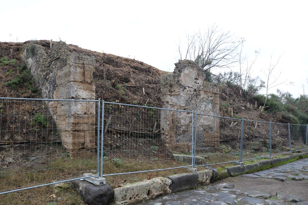 Via dell’Abbondanza, north side. December 2018. 
Looking east along insula III.7 from the unexcavated roadway (on left) next to III.7.1, doorway. Photo courtesy of Aude Durand.
