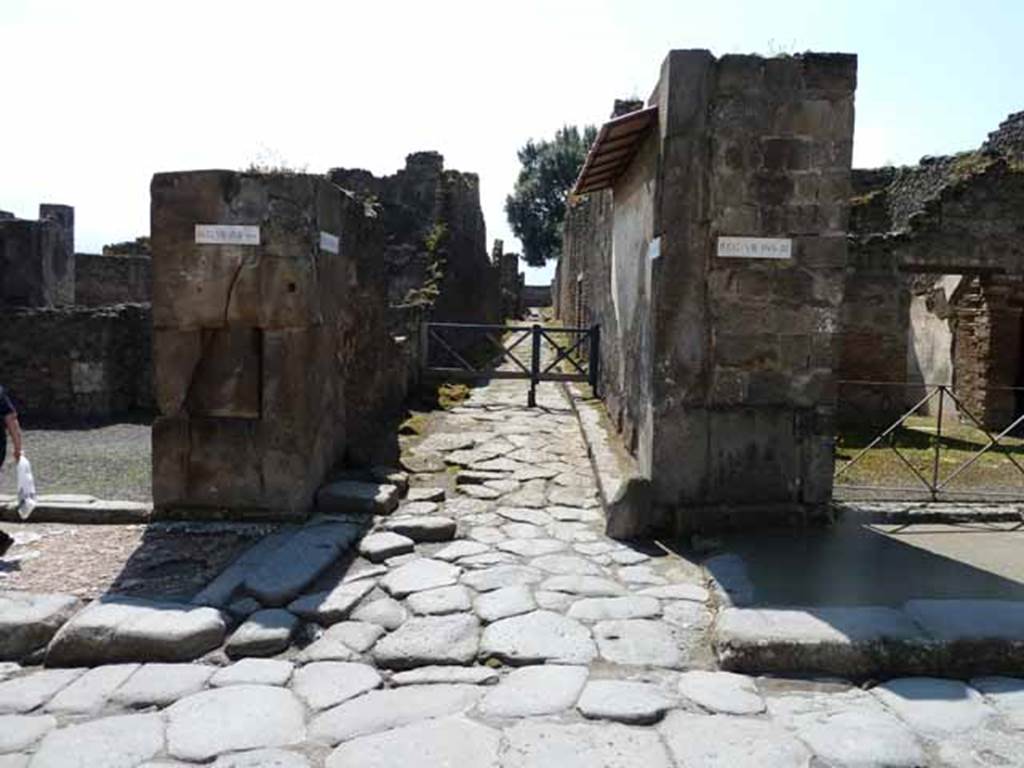 Via dell’Abbondanza, south side. May 2010. Junction with Vicolo dei Dodici (12) Dei, between VIII.5 and VIII.3. Looking south from junction.
