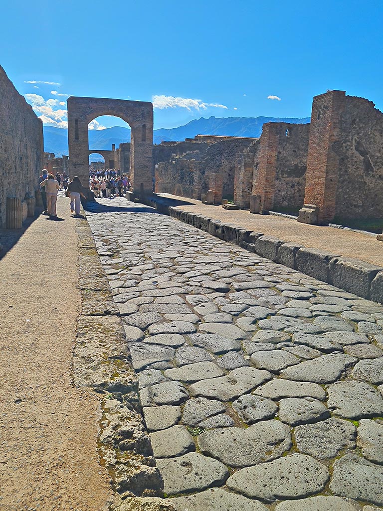 Via di Mercurio, October 2024. 
Looking south between VI.10 and VI.8, and through Arch to Via del Foro. Photo courtesy of Giuseppe Ciaramella.
