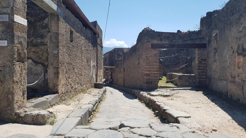 Vicolo del Lupanare August 2023. 
Looking south from junction with Via degli Augustali, with VII.1.42, on left and VII.12.15 Pompeii, on right. Photo courtesy of Maribel Velasco.
