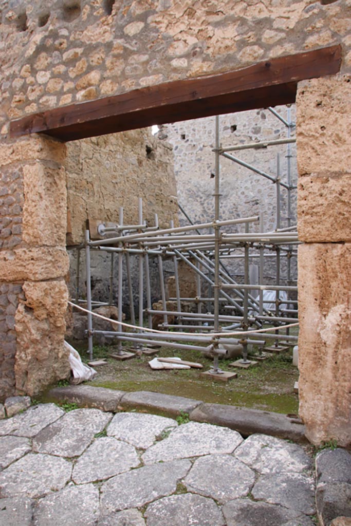 Vicolo dei Balconi, Pompeii. October 2022. 
Looking west to entrance doorway into stable, room A16, of Casa di Orione. Photo courtesy of Klaus Heese.

