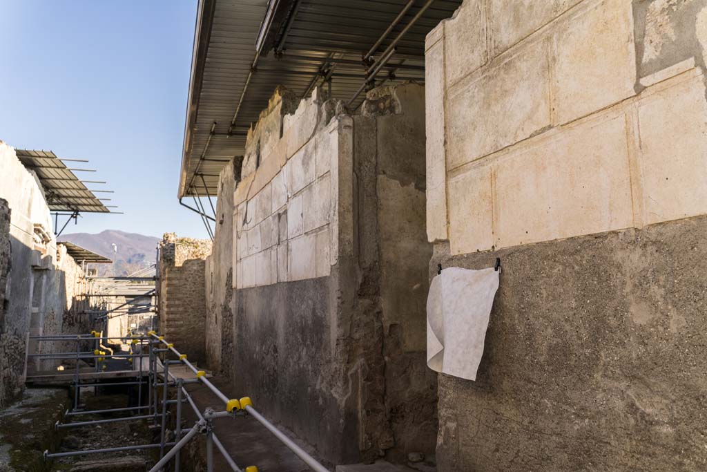 Vicolo dei Balconi, west side, Pompeii. April 2022. 
Looking south towards entrance doorway into Casa di Orione, in centre. Photo courtesy of Johannes Eber.
