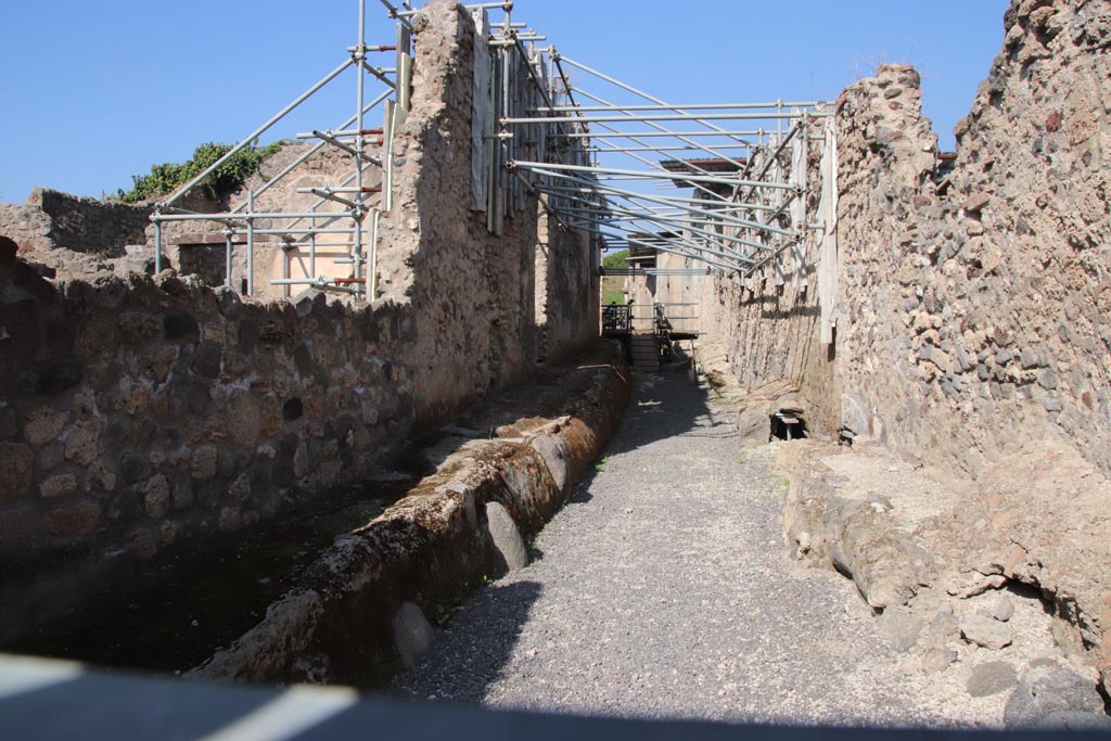 Vicolo dei Balconi, Pompeii. October 2023. 
Looking north from junction with Via di Nola. V.2.20 Pompeii is centre left, lit by sunlight. Photo courtesy of Klaus Heese.
