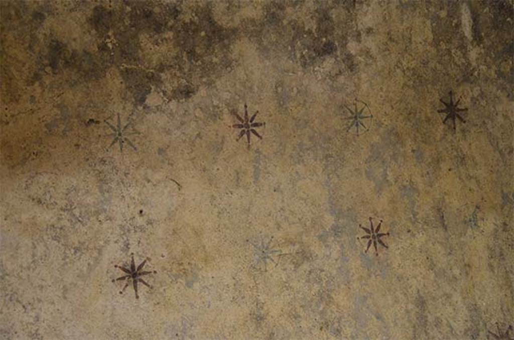Santa Maria Capua Vetere, Mithraeum. July 2014. Red and blue stars on the vault of the Mithraeum.
Photo courtesy of Carole Raddato from FRANKFURT, Germany [CC BY-SA 2.0], via Wikimedia Commons.
The vault of the Mithraeum is stuccoed and decorated with stars. 
These are painted inside a circle, they each have eight rays and they are alternately red and blue on a dark-yellow background. 
In the centre of them a very small hole is often visible. 
It is said that when it was discovered the vault was besprinkled with precious stones which were later on stolen; but among the loose earth was found a little circular piece of blue glass paste with a hole in the middle.
It therefore seems probable that these glass decorations (which may have been of various colours) were nailed into the stars. 
The vault symbolizes the heavens, and this is emphasized by the representations of Sol-Mithras on the western and Luna on the eastern wall.
See https://www.flickr.com/photos/carolemage/6924214139

