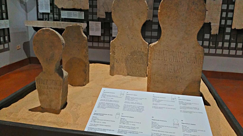 Display in Naples Archaeological Museum, 2 found at Fondo Santilli, 1 from Porta Marina tombs (centre left) and 1 (centre right) from tombs at Herculaneum Gate. June 2017.
Photo courtesy of Giuseppe Ciaramella.
According to the information card, cippus on left of photo above  -
Marble Sepulchral cippus, dated 50-79AD, inv.123247, 
“Petacia Montana, who lived 23 years”.
The family of the Petacii is attested at Capua, Pozzuoli and Miseno, as well as Pompeii.
(“Petacia Montana visse anni 23”.
La famiglia dei Petacii è attestata oltre che a Pompei a Capua, a Pozzuoli e Miseno).
