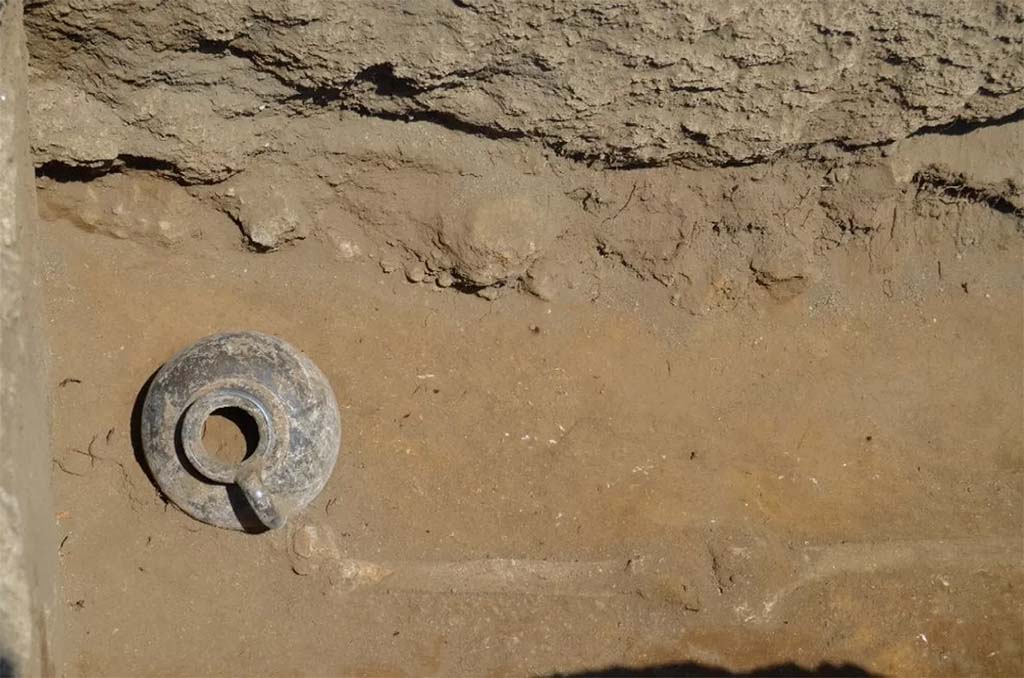 HGE32A Pompeii. June 2016. Tomb of a Samnite Man. The black painted jug next to the right foot of the deceased Samnite

La brocca a vernice nera accanto al piede destro del defunto sannita

Photograph � Parco Archeologico di Pompei.
