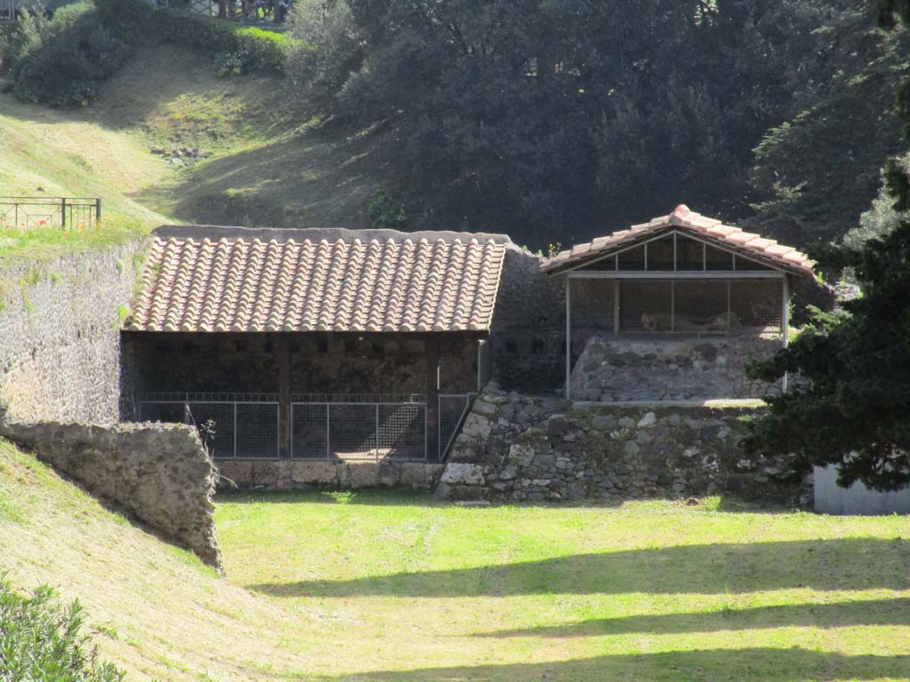 North-west side of Via delle Tombe. April 2019. Looking east towards display area showing the plaster-casts of some fleeing fugitives.
Three victims, two male and one female were found in September 1956. 
A fourth victim was found in May 1957. Plaster casts were made. Photo courtesy of Rick Bauer.

