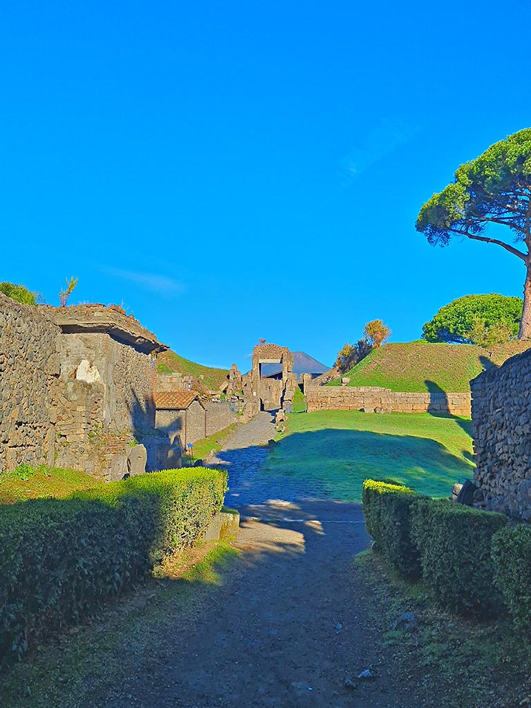 Pompeii Porta Nocera. October 2024. 
Looking north to junction of Via delle Tombe and Porta Nocera, tomb 1ES with two upright stones is on left. 
Photo courtesy of Giuseppe Ciaramella.
