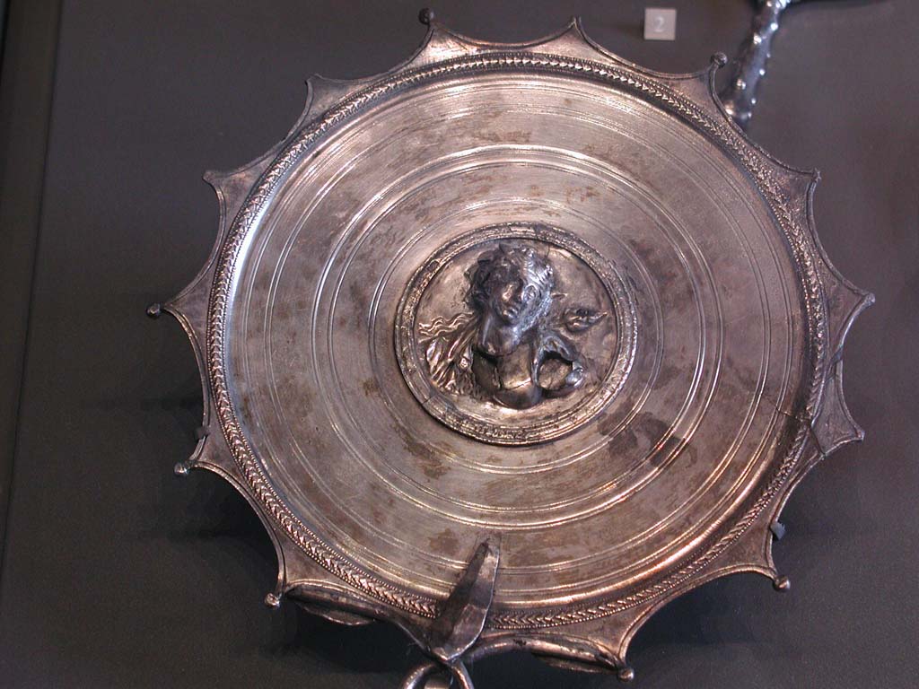 Villa della Pisanella, Boscoreale. Boscoreale silver hand mirror. In the center, in a medallion: bust of Bacchante.
According to De Villefosse, Mirror adorned with the bust of Ariadne and bearing the signature of the engraver M. Domitius Polygnos, with the indication of the weight of the piece.
Miroir à manche. Au centre, dans un médaillon : buste de Bacchante.
Selon De Villefosse, Miroir orné du buste d'Ariane et portant la signature du ciseleur M. Domitius Polygnos, avec l'indication du poids de la pièce.
Now in the Louvre, inventory number BJ2158.
De Villefosse H., 1902. L'argenterie et bijoux d'or du trésor de Boscoreale description des pièces conservées au Musée du Louvre - Monuments et Memories 5 1899 with supplement 1902, pl. XIX.
