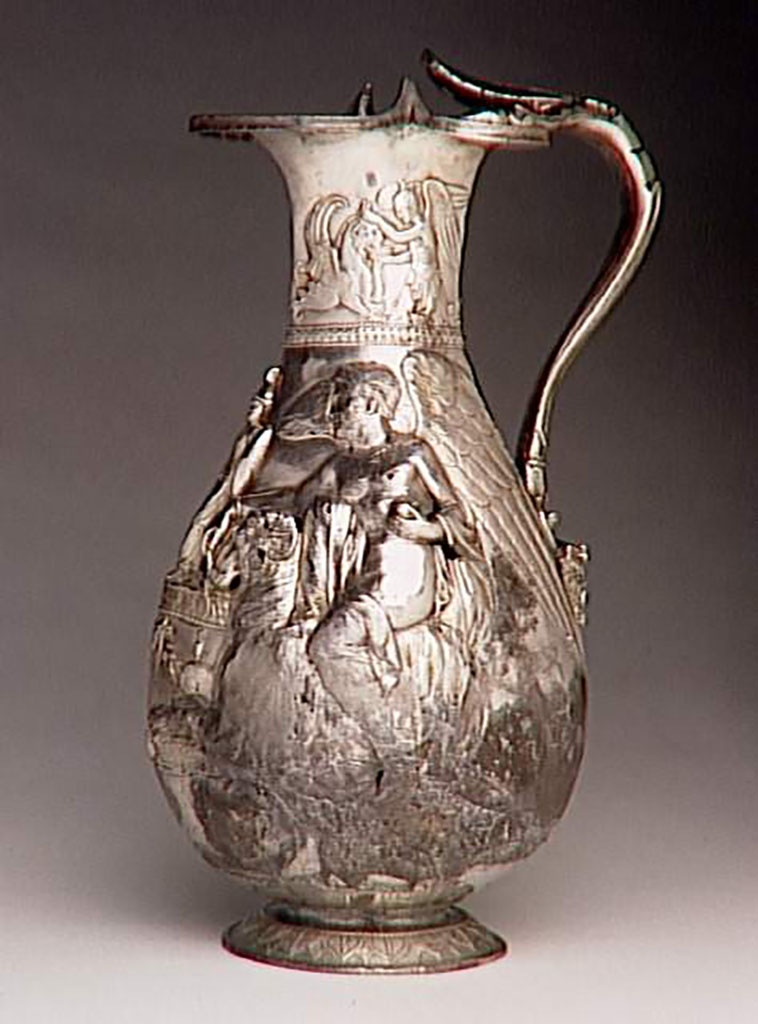 Villa della Pisanella, Boscoreale. Boscoreale Treasure. Oenochoe, silver wine vase with repousse decoration and traces of gilding. Height about 25 cm. Side 2.
On the neck: a winged genius gives water to a griffin. On the body: one victory on a ram, offers incense and an olive branch. Handle terminated at bottom with a head of Silenus crowned with ivy.
Oenochoé du trésor de Boscoreale - Vase à vin en argent décors repoussé, traces de dorure. Hauteur environ 25 cm. Côté 2.
Sur le col : un génie ailé abreuvant un griffon. Sur la panse: une victoire sur un bélier, offre de l'encens et un rameau d'olivier. Anse terminé en bas par une tête de Silène couronnée de lierre.
Photo © RMN-Grand Palais (musée du Louvre) / Hervé Lewandowski.
Now in the Louvre, inventory number BJ 1898.