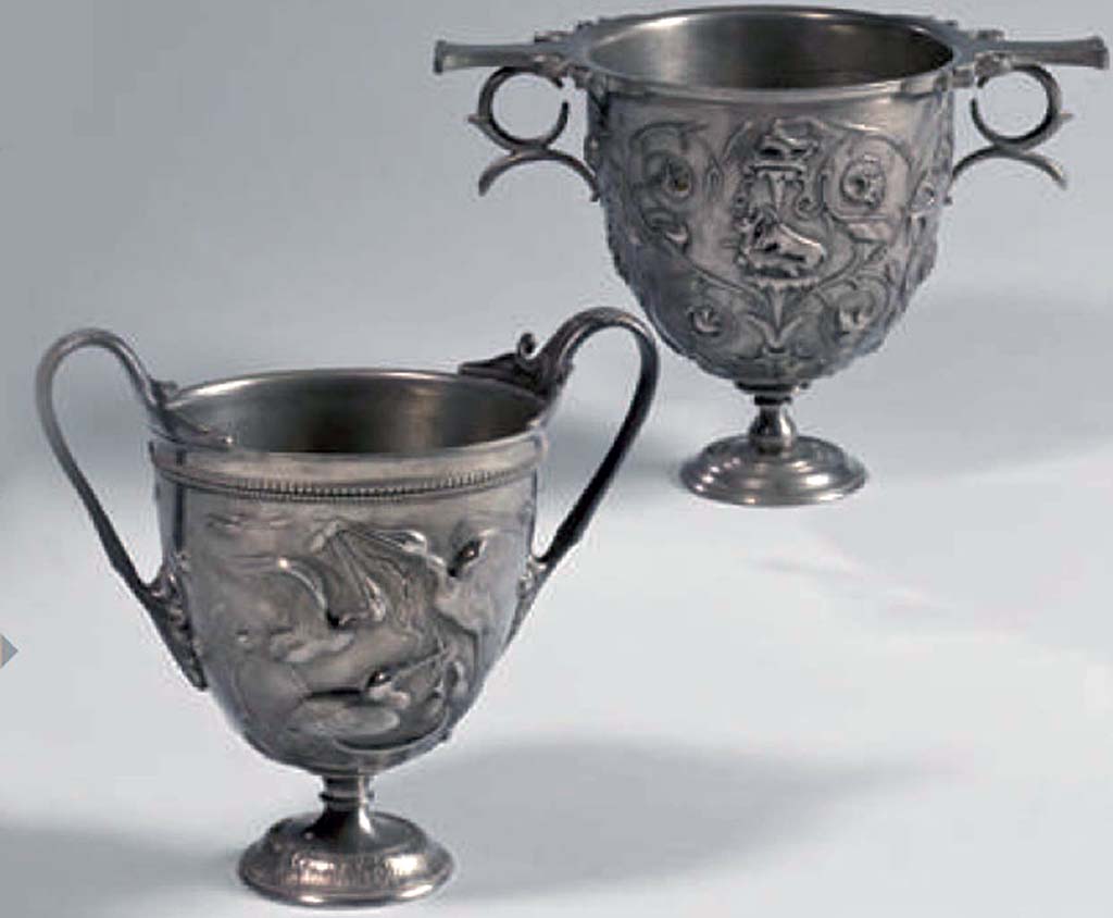 Villa della Pisanella, Boscoreale. At the back is the reverse side of the silver Cantharus decorated with floral scrolls and animal fights.
A l'arrière se trouve l'inverse du Cantharus argenté à décor de rinceaux floraux et combats d'animaux.
Now in the Louvre, inventory number BJ1907.
Voir/See De Villefosse H., 1899. L'argenterie et bijoux d'or du trésor de Boscoreale description des pièces conservées au Musée du Louvre: Monuments et Memories 5 1899 with supplement 1902, pl. X.
At the front is one of a pair of cantharus, with scenes with storks.
Two scenes unfold around the storks' nest: the parents bring prey back to their young and are challenged by an intruder
À l'avant est l'un d'une paire de cantharus, avec des scènes avec des cigognes.
Deux tableaux se déroulent autour du nid des cigognes : les parents rapportent à leurs petits des proies qui leur sont disputées par un intrus
Now in the Louvre, inventory number BJ1904.
Voir/See De Villefosse H., 1899. L'argenterie et bijoux d'or du trésor de Boscoreale description des pièces conservées au Musée du Louvre: Monuments et Memories 5 1899 with supplement 1902, pl. XIII.