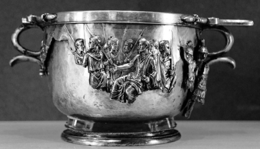 Villa della Pisanella, Boscoreale. Silver skyphos, Augustus and the barbarians.
Skyphos argent�, Auguste et les barbares.
Now in the Louvre, inventory number BJ2366.
According to Kuttner, between 1899 and 1991 no author after H�ron de Villefosse seems to have viewed the cups first-hand, or made an effort to do so.[18] They dropped out of sight, and the scholarly consensus by the 1970s was that they had been mislaid by the close of the Second World War and that the Augustus cup might have been destroyed.[19] As Francois Baratte informs me, the Rothschild family believes that the cups never left family control; they did, however, pass through a period when they were vulnerable to damage. From first-hand examination of the cups, two points emerge. For some unspecified period they were stored or passed around in such a way that previous damage was exacerbated, that is, holes already torn in the relief shell widened around their edges; this is the nature of the damage on the Tiberius cup, and it conforms to the twentieth-century "legend" of that cup's continued existence. The second point is that one of the cups, the Augustus cup, fell prey to vandalism�not the complete destruction of its "legend," but active mutilation all the same. Great swathes of silver have been torn off the core on both sides of this cup, as if someone had absentmindedly peeled a label from a beer bottle; this may be accidental damage. However, in at least one place one can see that someone has cut crudely around the outlines of figures in high relief, as if to detach as a keepsake one figure at a time: such crude shear marks are clearly visible around the missing officer who stood behind Augustus, and the neat rectangular tear in front of Roma may also demonstrate such clipping. 

Selon Kuttner, entre 1899 et 1991, aucun auteur apr�s H�ron de Villefosse ne semble avoir vu les coupes de premi�re main, ni fait un effort pour le faire. Ils sont tomb�s hors de vue, et le consensus savant par les ann�es 1970 �tait qu'ils avaient �t� �gar�s par la fin de la Seconde Guerre mondiale et que la coupe d'Auguste aurait pu �tre d�truite. [19] Comme m'informe Fran�ois Baratte, la famille Rothschild croit que les tasses n'ont jamais quitt� le contr�le de la famille; ils ont cependant travers� une p�riode o� ils �taient vuln�rables aux dommages. De l'examen de premi�re main des tasses, deux points �mergent. Pendant une p�riode ind�termin�e, ils ont �t� entrepos�s ou pass�s autour de telle mani�re que les dommages ant�rieurs ont �t� exacerb�s, c'est-�-dire les trous d�j� d�chir�s dans la coquille en relief e sont �largis autour de leurs bords; c'est la nature des dommages sur la coupe Tib�re, et il est conforme � la �l�gende� du XXe si�cle de l'existence continue de cette coupe. Le deuxi�me point c�est que l'une des tasses, la coupe Auguste, a �t� a proie du vandalisme, non pas la destruction compl�te de sa � l�gende �, mais la mutilation active tout de m�me. De grandes bandes d'argent ont �t� arrach�es du noyau des deux c�t�s de cette tasse, comme si quelqu'un avait distraitement �pluch� une �tiquette d'une bouteille de bi�re; il peut s'agit peut-�tre de dommages accidentels. Cependant, dans au moins un endroit on peut voir que quelqu'un a coup� grossi�rement autour des contours des figures en haut relief, comme pour se d�tacher comme un souvenir une figure � la fois: ces marques de cisaillement brut sont clairement visibles autour de l'officier disparu qui se tenait derri�re Auguste , et la d�chirure rectangulaire soign�e devant les Roms peut �galement d�montrer une telle coupure.
Voir/See Kuttner, Ann L. 1995. Dynasty and Empire in the Age of Augustus: The Case of the Boscoreale Cups  Berkeley: University of California Press, pp. 8-9.
https://publishing.cdlib.org/ucpressebooks/view?docId=ft309nb1mw&chunk.id=d0e182&toc.id=d0e182&brand=eschol