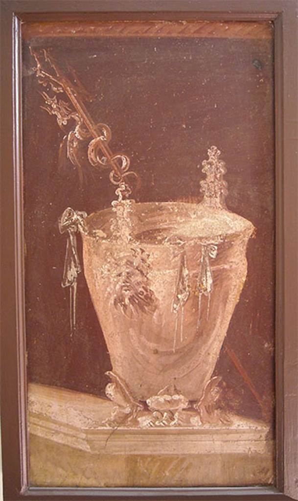 Villa of P. Fannius Synistor at Boscoreale. Peristyle E. Painting of a situla placed on a podium as an athletic winner�s reward. It has three low feet in the form of feline legs, with a tapered body with a high lip slightly turned. The handles are in the form of Silenus masks.
Outside the bowl hang the ribbons of the winner, while behind it, and placed obliquely a trident with twisted a fantastic animal. Now in Naples Archaeological Museum.  Inventory number s.n. 7. See Sampaolo V. and Bragantini I., Eds, 2009. La Pittura Pompeiana. Electa: Verona. 56b, p. 176.