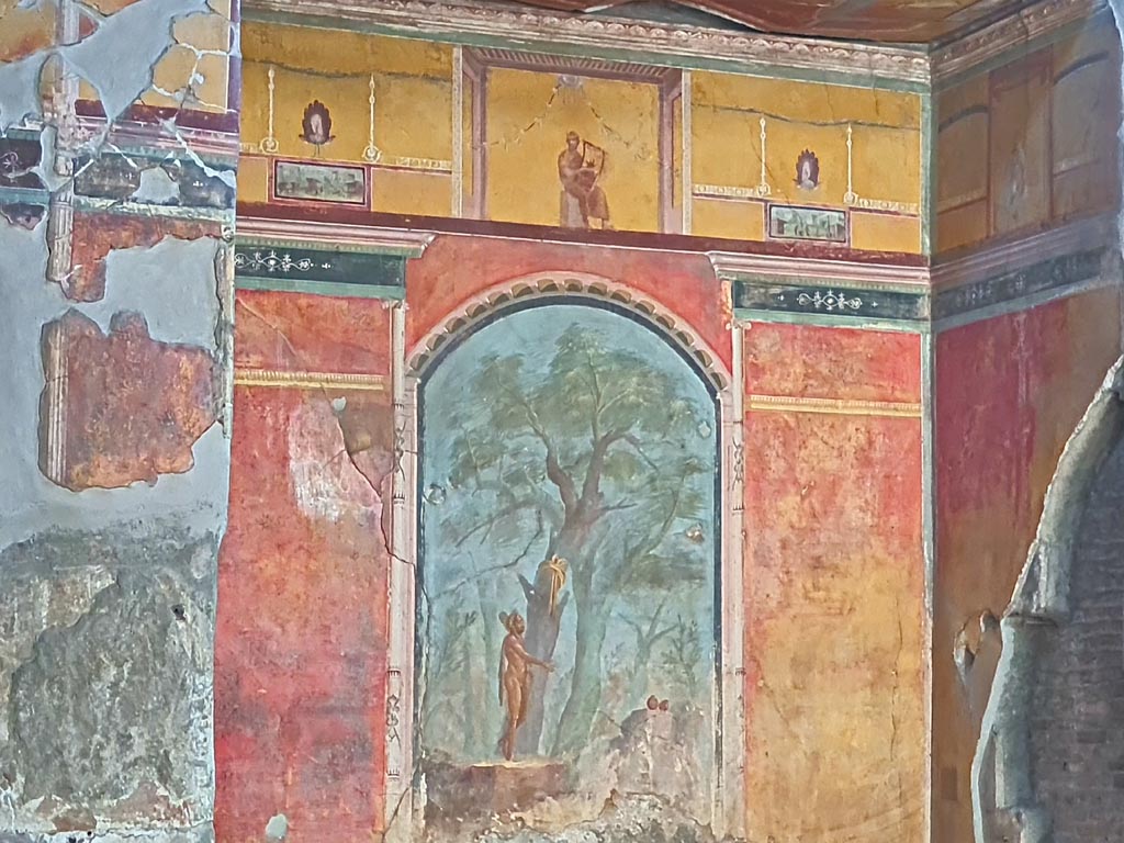Oplontis Villa of Poppea, October 2023. Room 8, painted upper east wall in recess. 
In the centre is a painting of a poet playing the lyre. On either side of him are painted peacocks. 
Below them are painted panels of scenes and landscapes taken from daily life. Photo courtesy of Giuseppe Ciaramella.
