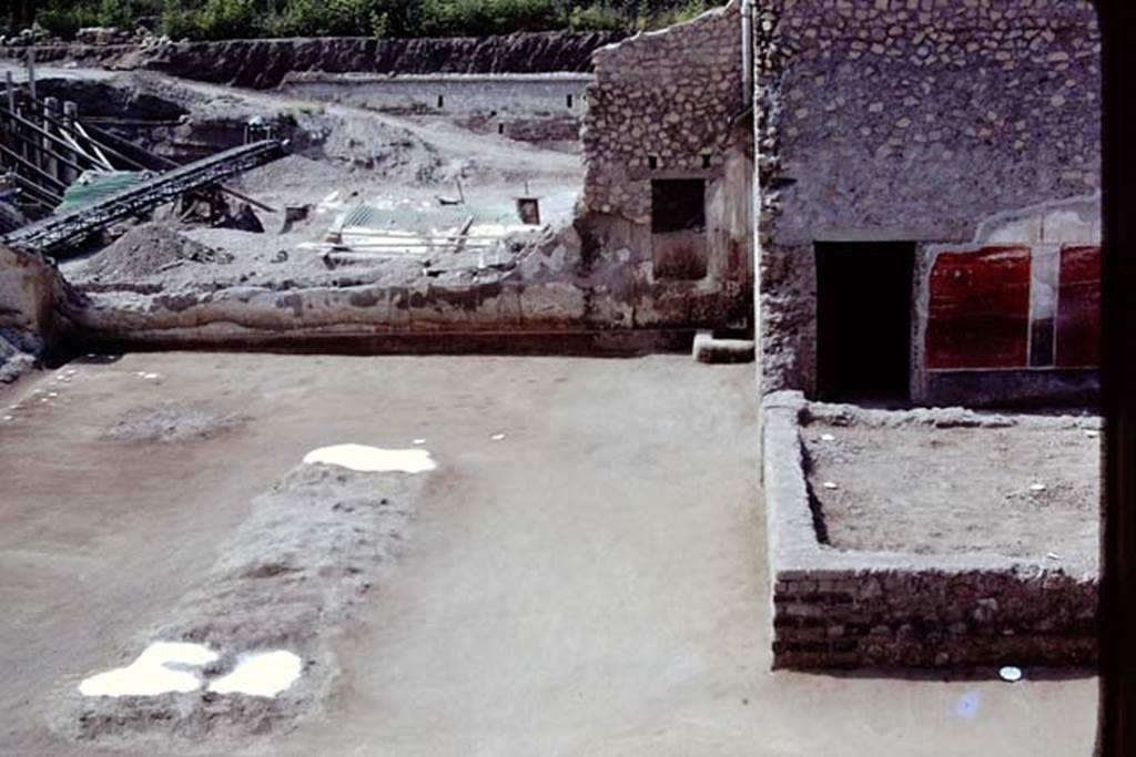 Oplontis, 1975. Looking south at east end of north garden towards area 59, the south-east peristyle, and room 58, with painted exterior wall of room 55. 
Photo by Stanley A. Jashemski.   
Source: The Wilhelmina and Stanley A. Jashemski archive in the University of Maryland Library, Special Collections (See collection page) and made available under the Creative Commons Attribution-Non Commercial License v.4. See Licence and use details. J75f0460

