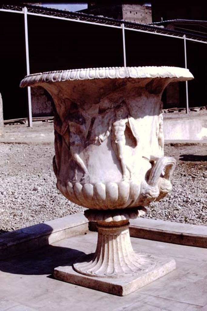 Oplontis, 1978. Large crater fountain vase positioned in the centre of the south side of the pool.  Photo by Stanley A. Jashemski.   
Source: The Wilhelmina and Stanley A. Jashemski archive in the University of Maryland Library, Special Collections (See collection page) and made available under the Creative Commons Attribution-Non Commercial License v.4. See Licence and use details. J78f0048
According to Wilhelmina, �We were delighted to see they had discovered the base of the beautiful marble crater fountain in a small pool in the garden area on the south side of the swimming pool where the crater had been originally located. We had admired the fountain on a previous trip, for it had been found earlier, in the rear portico of the villa where it had been stored, possibly after the earthquake.�
See Jashemski, W.F., 2014. Discovering the Gardens of Pompeii: Memoirs of a Garden Archaeologist, (p.263).
According to Wilhelmina, �the base of the large crater fountain was found in fragments in passage 53, where it had been stored at the time of the eruption�.
See Jashemski, W. F., 1993. The Gardens of Pompeii, Volume II: Appendices. New York: Caratzas. (p.298).
