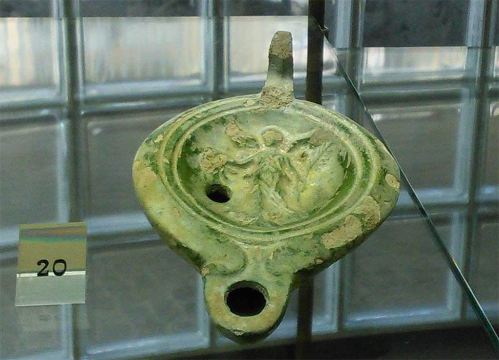 Boscoreale, Villa rustica in via Casone Grotta, proprietà Risi di Prisco. Green glazed terracotta lamp with volutes and rounded beak.
In the centre is a representation of Nike.
